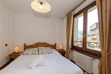 A small bedroom with a bed and a window