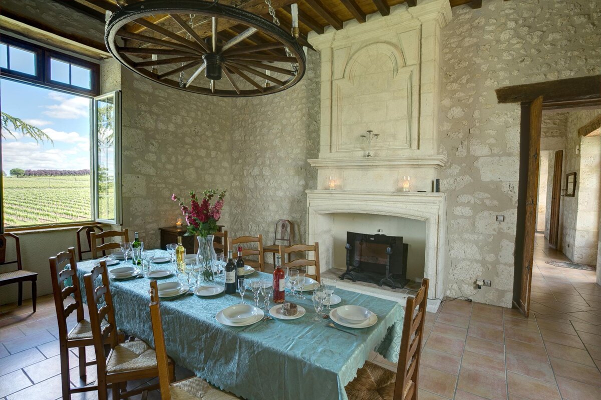 A dining room with a table and chairs and a fireplace