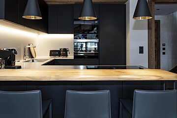 A black smeg toaster sits on a counter in a kitchen