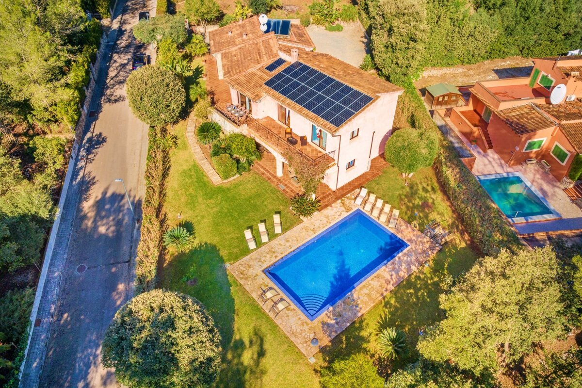 An aerial view of a house with solar panels on the roof