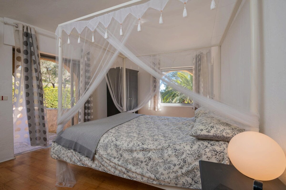 A bedroom with a canopy bed and a window