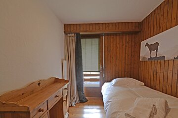 A bedroom with a single bed and a picture of a horse on the wall