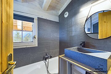 A bathroom with a sink and a window that says white management