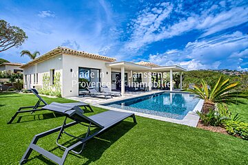 A swimming pool in front of a house that says made in provence immobilier