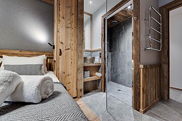 A bathroom with a walk in shower and a sink
