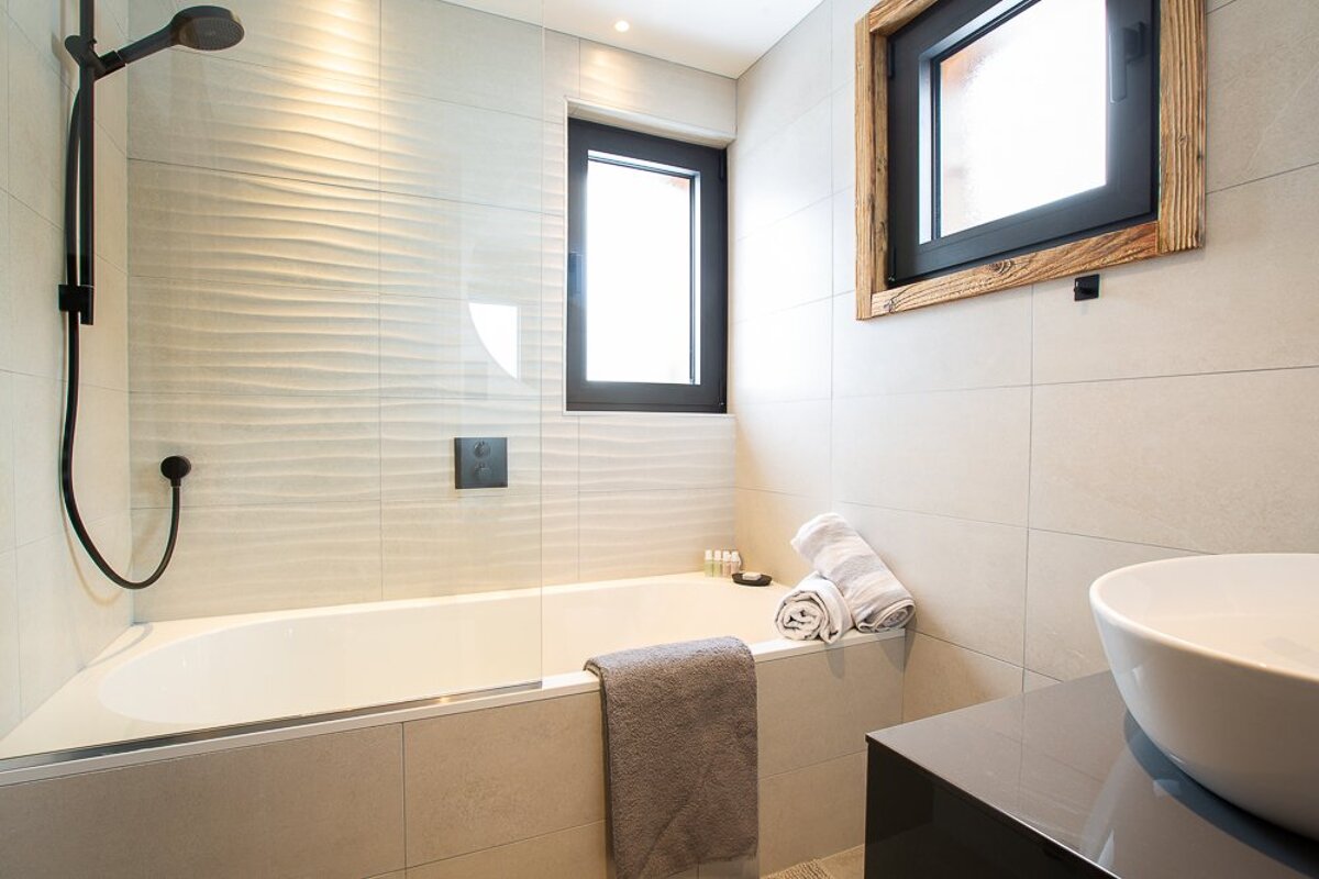 A bathroom with a bathtub a sink and a window