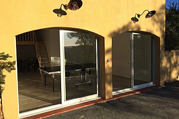 A ping pong table sits in front of a sliding glass door