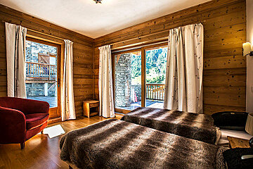 A bedroom with two beds and a red chair