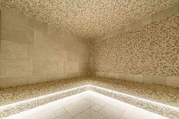 A corner of a room with tiles on the walls and ceiling