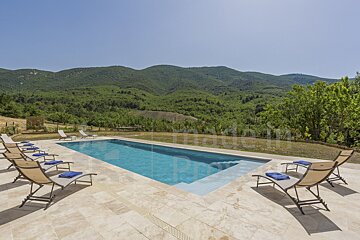 A swimming pool surrounded by chairs and mountains with the word prestige in the background