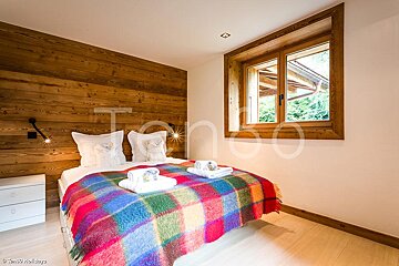 A bedroom with a bed and a window and the word tango on the wall