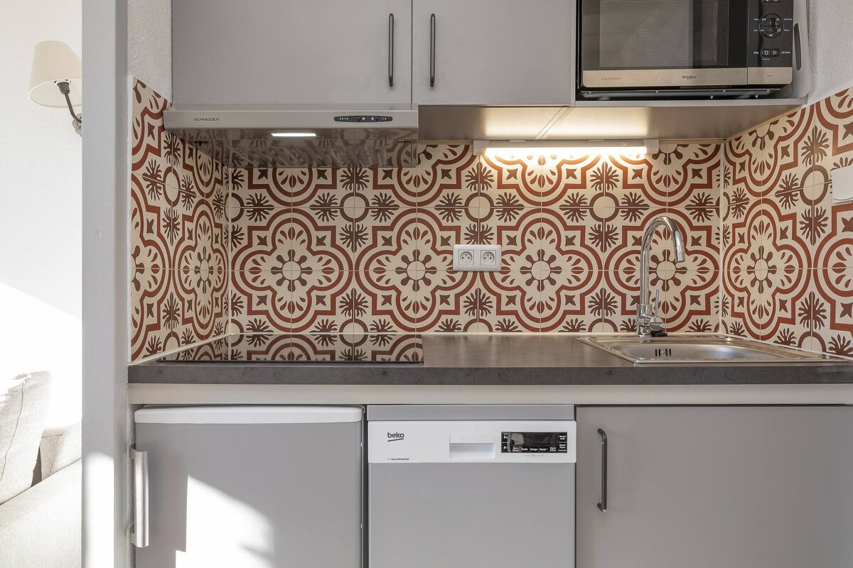 A kitchen with a beko dishwasher and a whirlpool microwave