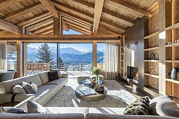 A living room with a fireplace and a view of the mountains