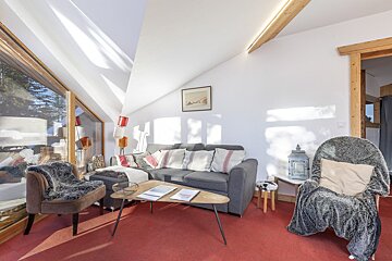 A living room with a round mirror and a flat screen tv