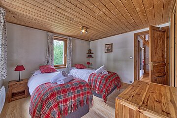 A bedroom with two beds and a wooden dresser
