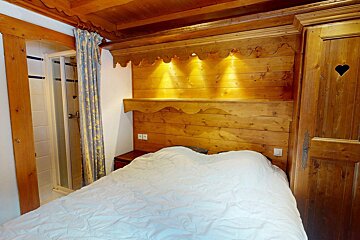 A bedroom with a bed and a heart on the door