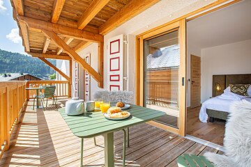 A balcony with a green table and a plate of food on it