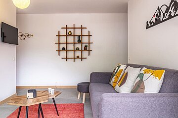 A living room with a couch a table and a tv
