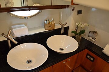 A bathroom with two sinks and a basket of lotion