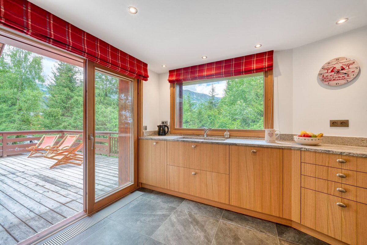 A kitchen with wooden cabinets and a clock on the wall that says ' swiss ' on it