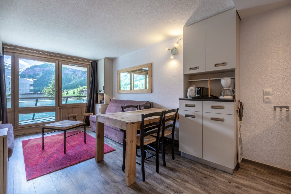 A living room with a table and chairs and a coffee maker