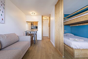 A bedroom with a bunk bed and a couch