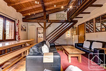 A living room with a couch and a table with alpine property written on the bottom