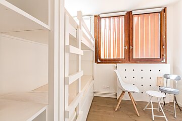 A bedroom with a white blanket on the bed