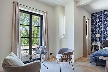 A room with a chair and a table that says made in provence by immobilier