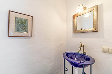 A bathroom with a blue sink and a mirror