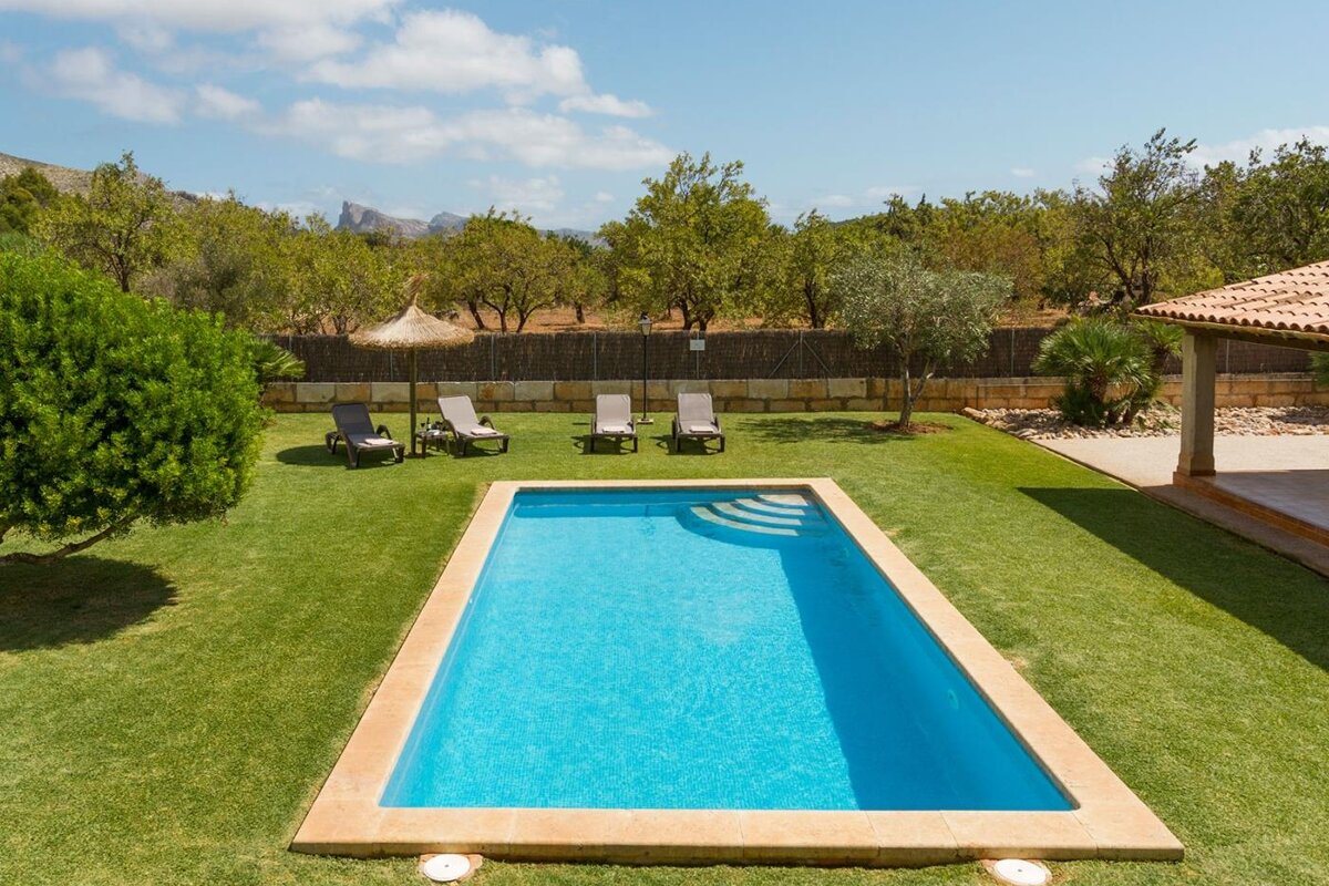 A large swimming pool surrounded by chairs and trees