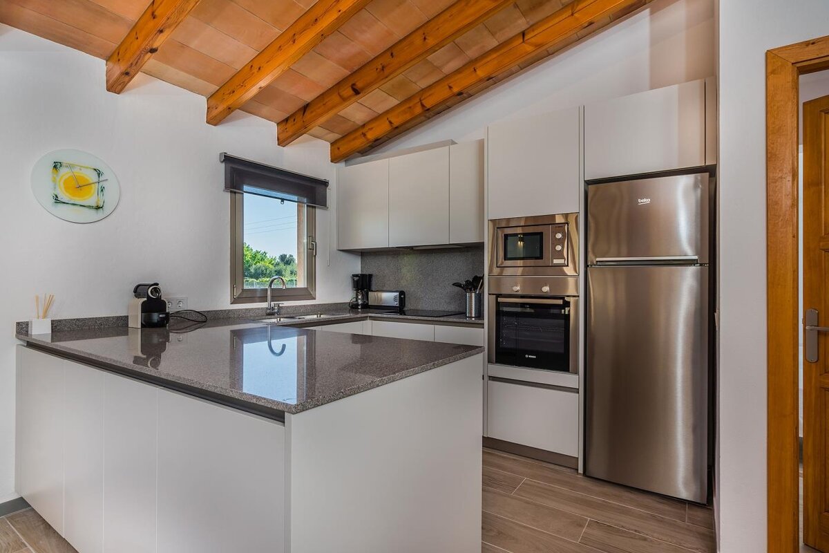 A kitchen with stainless steel appliances and a beko refrigerator