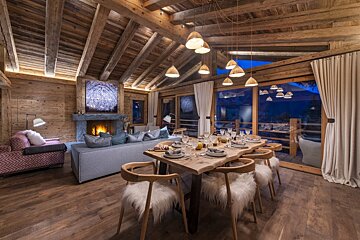 A living room with a table and chairs and a fireplace