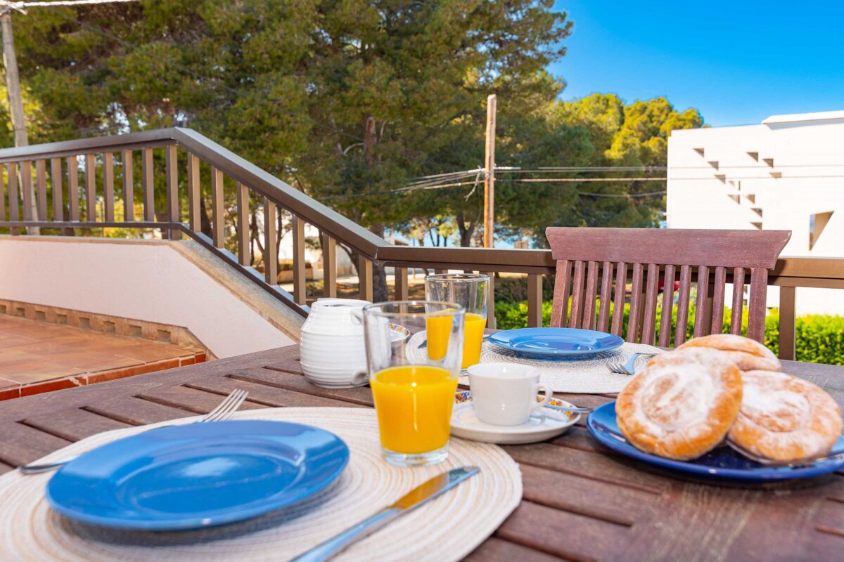 A table with plates and glasses of orange juice on it