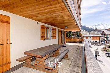 A balcony with a wooden table and benches and the letters vjp on it