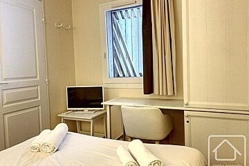 A bedroom with a desk and a flat screen tv