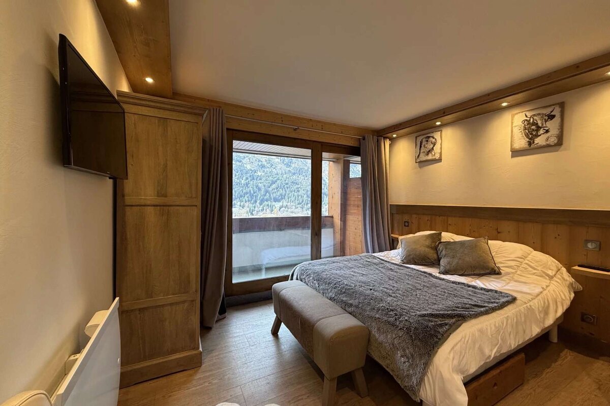 A bedroom with a large bed and a flat screen tv