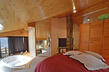 A bedroom with a bathtub and a fireplace