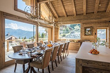 A dining room with a large table and chairs