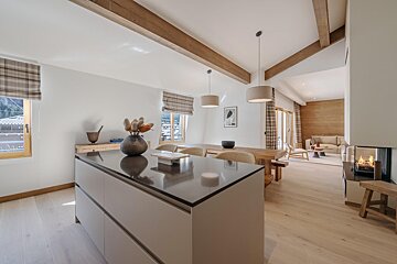 A kitchen with a large island and a dining table