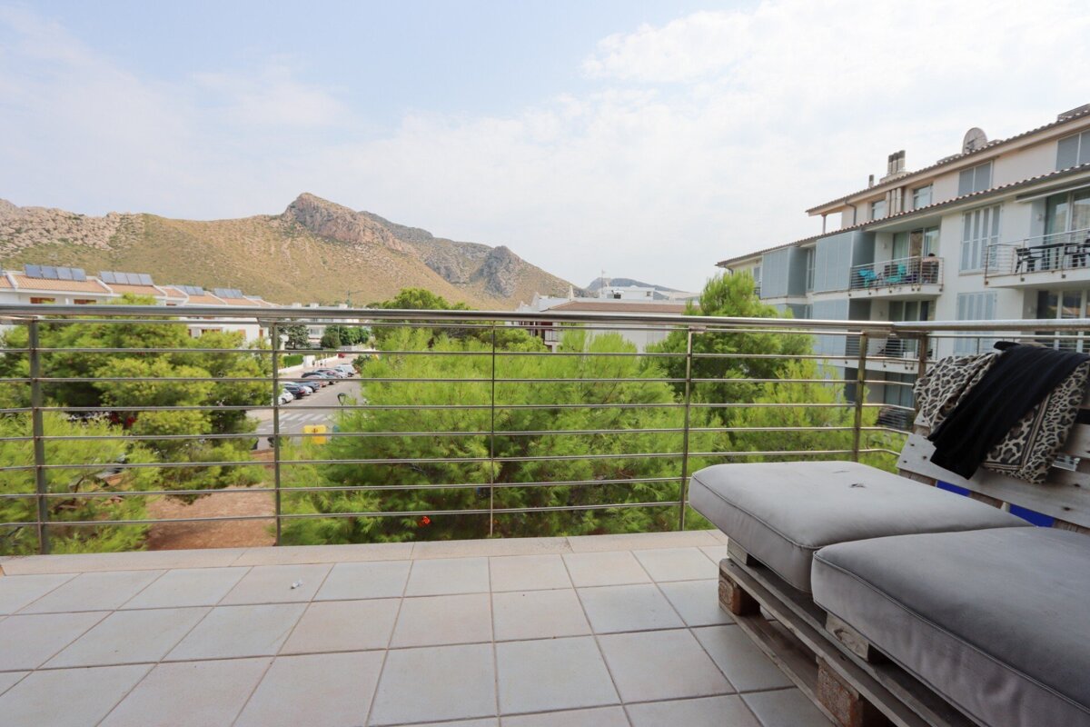 A balcony with a view of a mountain and trees