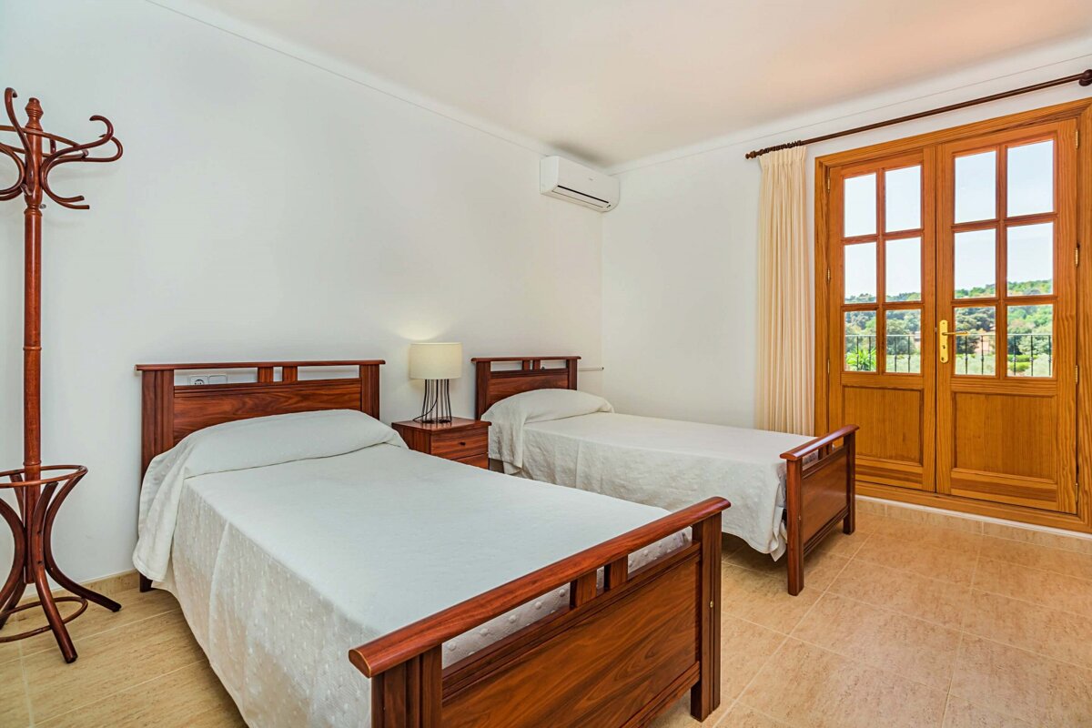 A bedroom with two twin beds and a wooden door