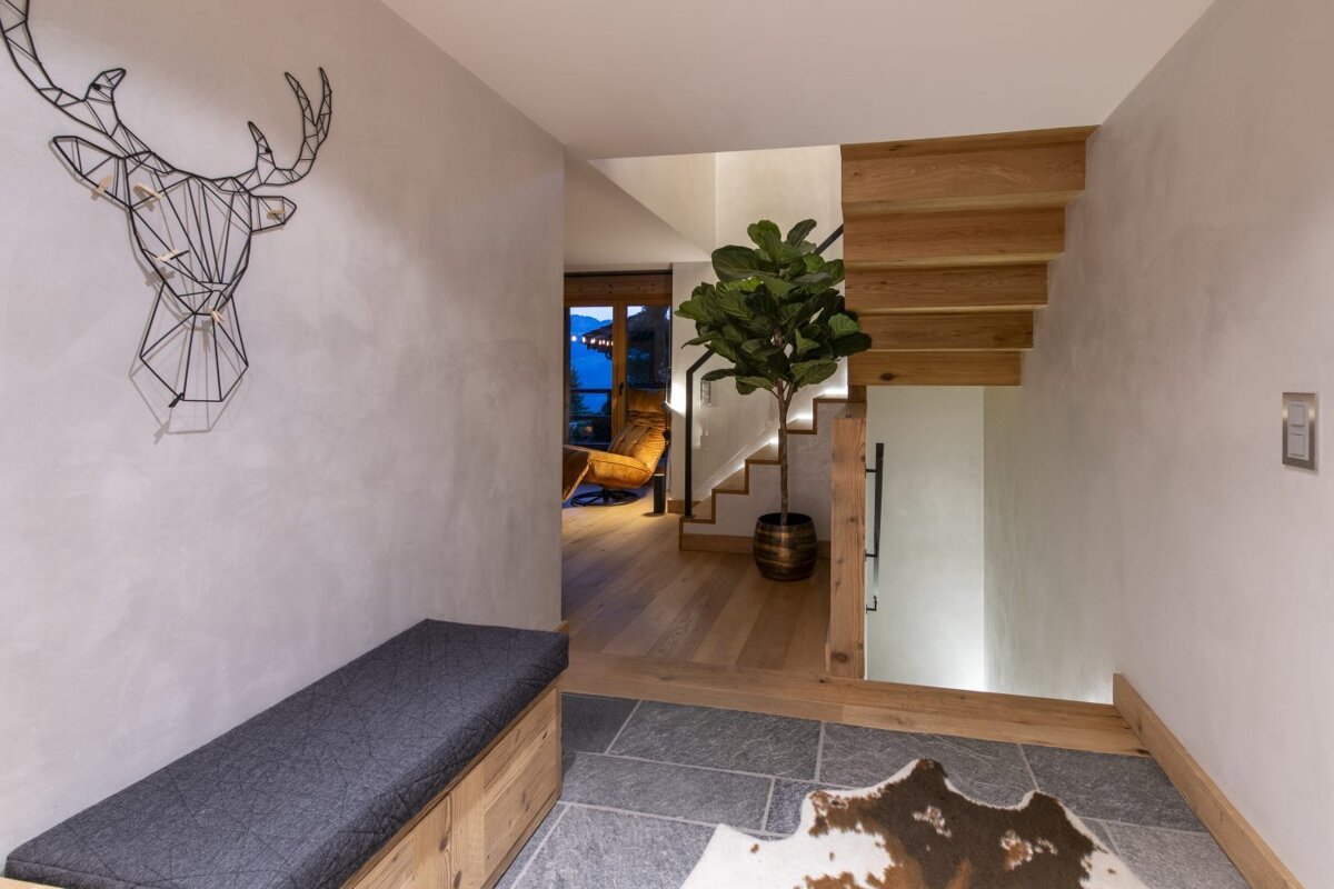 A staircase with a deer head on the wall above it
