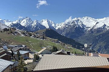 A view of a snowy mountain range from a balcony