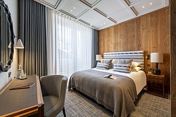 A hotel room with a large bed and a desk