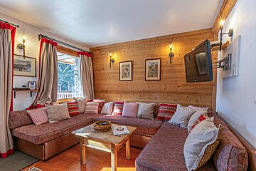 A living room with a sectional couch and a flat screen tv