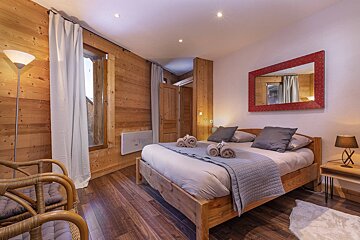 A bedroom with a large bed and a red mirror