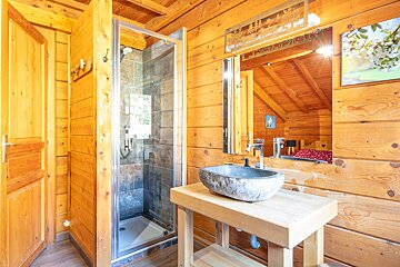 A bathroom in a log cabin with a stone sink