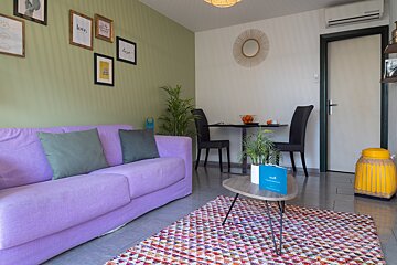A living room with a purple couch and a table