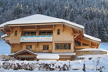 A house with a sign that says www.reach4thealps.com